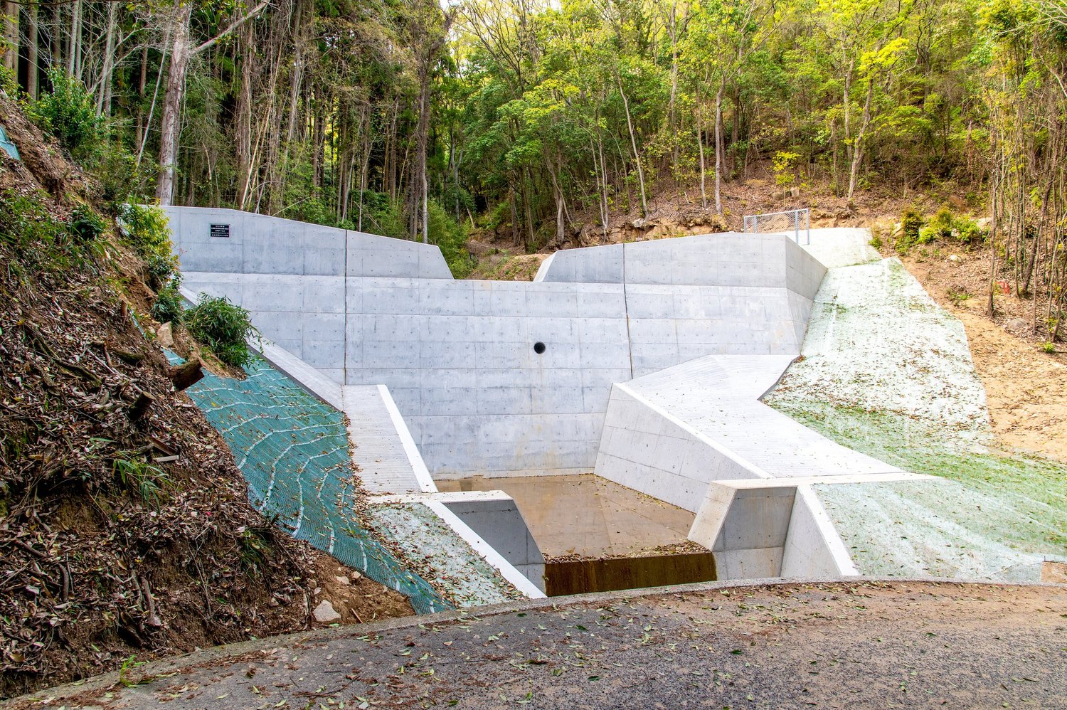 A concrete water management structure in a wooded landscape (representative image)